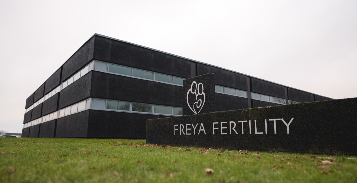 Außenansicht der Freya Fertility Klinik mit modernem Gebäude und Logo auf dem Firmenschild.